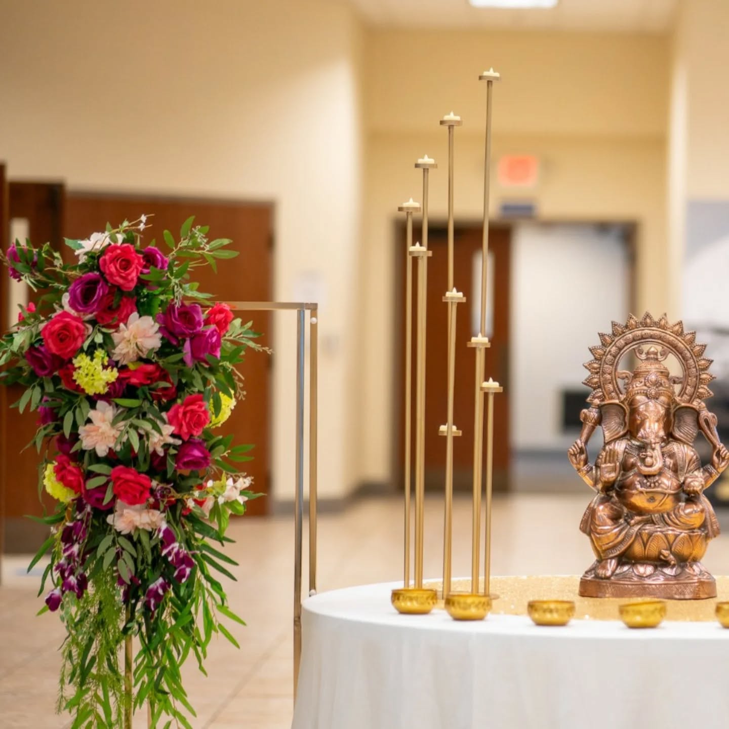 Vibrant cultural ceremony setup with colorful drapes and floral decor