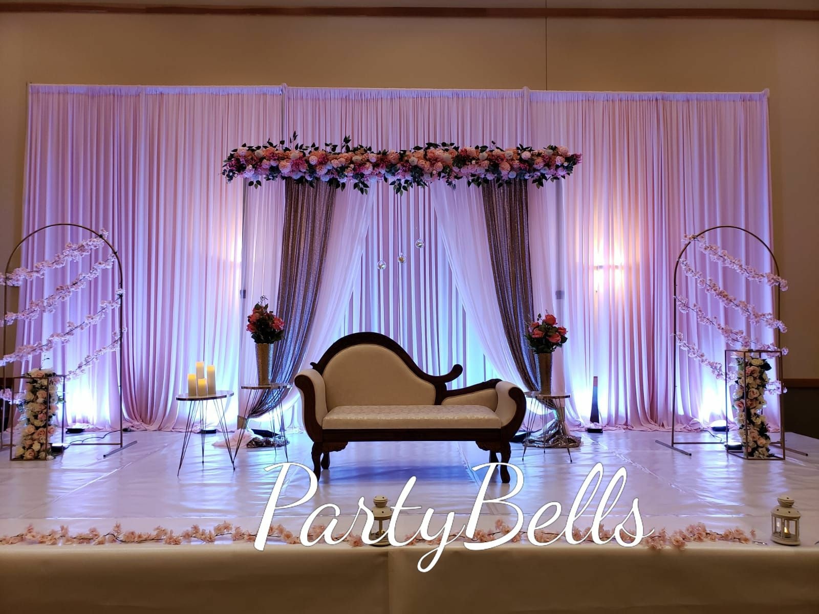 Romantic wedding ceremony stage with floral arch and elegant draping